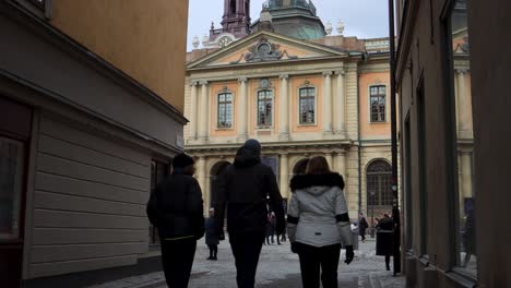 People-walk-in-alley-by-Swedish-Academy-and-Nobel-Prize-Museum,-static