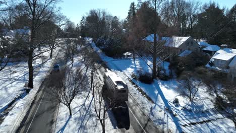 Aerial-tracking-shot-of-city-bus-on-road-in-winter