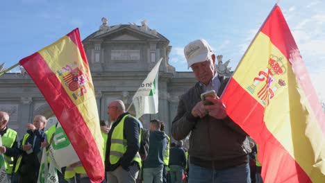 A-Spanish-farmer-protester-holds-a-Spanish-flag-as-farmers-and-agricultural-union-protesters-gathered-at-Puerta-de-Alcalá-in-Madrid,-protesting-against-unfair-competition-and-agricultural-policies