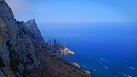 Aerial-shot-of-an-ocean-with-a-hill-cliff-during-daytime