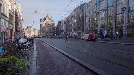 Wide-view-of-public-trams-riding-through-idyllic-city-in-Amsterdam,-Netherlands