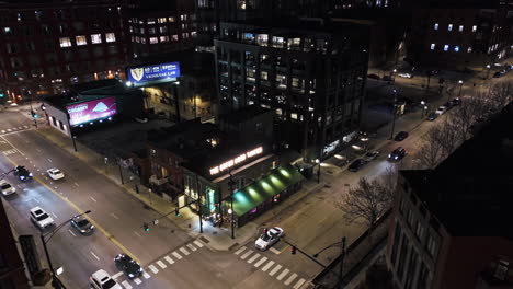 Traffic-at-the-Green-Door-Tavern,-night-in-River-North,-Chicago---Aerial-view