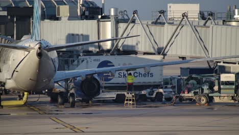 Truck-Delivering-Catering-to-the-Parked-Airplane,-B737-Max-Taxiing-By