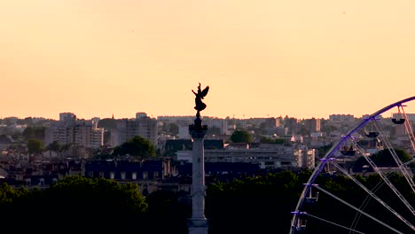 Column-Monument-of-Girondins-with-winged-victory-angel-and-Ferris-Wheel-in-Bordeaux-France-during-wine-fair,-Aerial-dolly-right-shot