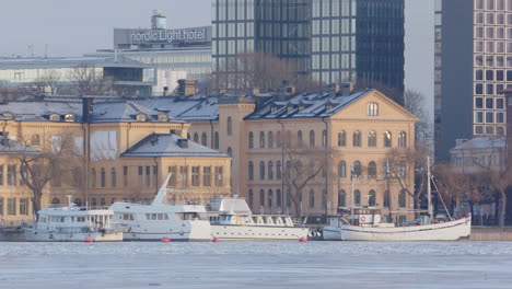 Moored-boats-on-iced-Lake-Malaren-on-Stockholm-waterfront,-telephoto