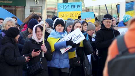 Women-clap-hands-with-signs-protesting-Putin’s-war-in-Ukraine,-slomo