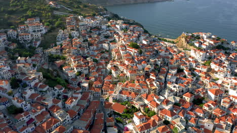 Aérea:-Vista-Panorámica-De-La-Ciudad-De-Skopelos-En-Espóradas,-Grecia-Durante-La-Puesta-De-Sol