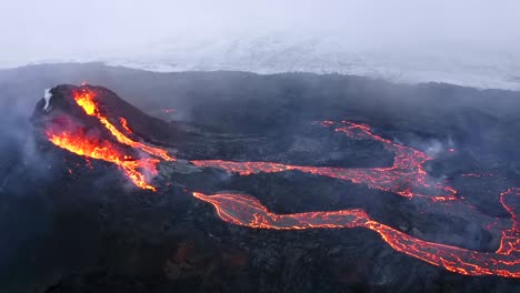 Mit-Einer-4K-Drohne-Aufgenommene-Luftaufnahmen-Zeigen-Eine-Landschaft-Aus-Vulkanfeldern-Mit-Fließender-Lava-Und-Wirbelndem-Rauch