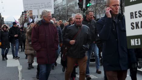 Covid-vaccination-protesters-march-with-signs-in-Stockholm,-Sweden