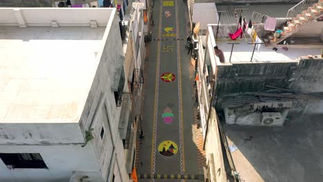 Aerial-drone-view-Different-types-of-Jai-Shri-Ram-rangolis-are-seen-on-the-road-between-the-buildings-and-many-people-are-looking-at-the-rangolis