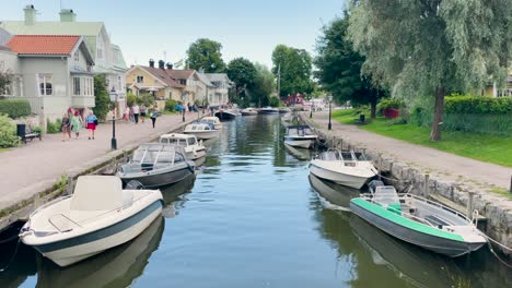 La-Gente-Camina-Por-Barcos-Atracados-En-Las-Orillas-De-Los-Ríos-En-La-Ciudad-De-Trosa-En-Suecia