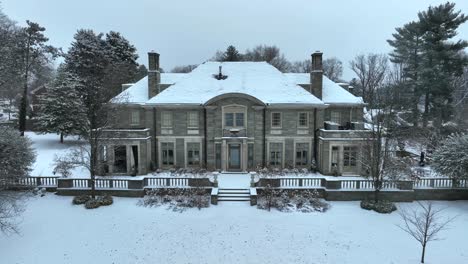 Aerial-establishing-shot-of-a-large-mansion-covered-in-snow