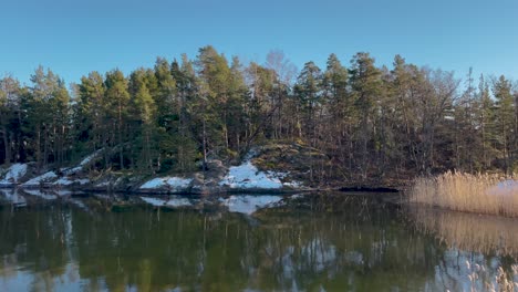 Tranquila-Escena-Invernal-De-Una-Isla-Cubierta-De-Nieve-En-El-Archipiélago-De-Estocolmo,-Reflejada-En-Aguas-Tranquilas