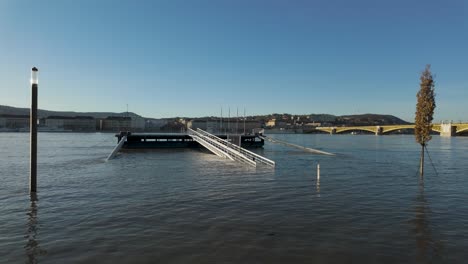 Flooded-Dock-in-Budapest,-Hungary,-during-the-flooding-of-Danube-River-with-Buda-Castle-in-the-background---December-28,-2023