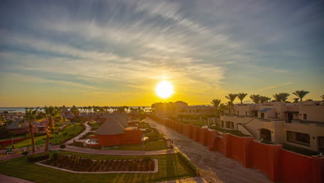 Magnificent-time-lapses-of-the-sunrise-on-the-horizon-with-a-hotel,-palm-trees-and-the-sea-in-the-background