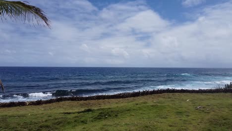 Tiefblaues-Meer-Bricht-Auf-Den-Philippinen-Mit-Brechenden-Wellen,-Im-Vordergrund-Eine-Palme