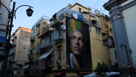 Downward-Pan-of-Gennaro-Lifelike-Graffiti-Painting-on-Gritty-Streets-of-Naples