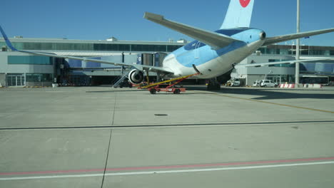 Travelling-along-the-runway-at-a-busy-airport-with-airliner-airplanes-on-the-tarmac-at-the-terminal-building-and-service-vehicles