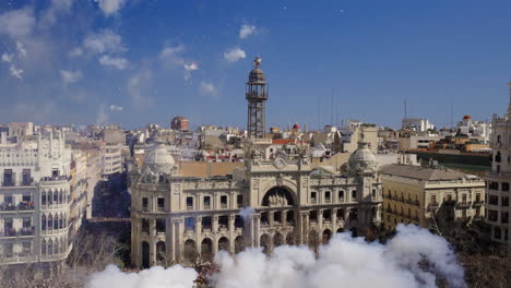 A-stunning-view-from-the-Edificio-Correos-captures-the-heart-of-Valencia-during-La-Mascleta-for-the-Fallas-festival,-fireworks-illuminating-the-scene-and-a-captivating-fog-adding-drama-to-the-view