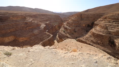 Inmenso-Cañón-Mides-Bajo-Un-Cielo-Azul-Claro-En-Túnez,-Mostrando-Paisajes-áridos-Y-Formaciones-Rocosas-En-Capas