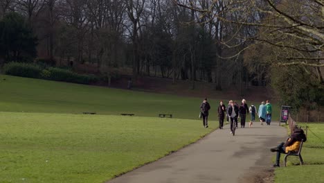 Gente-Paseando-Perros,-Ciclistas-Dentro-De-Un-Soleado-Y-Tranquilo-Parque-Queens,-En-El-Lado-Sur-De-Glasgow