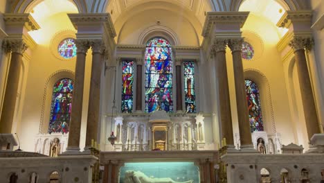 A-reveal-in-4K-inside-of-St-Teresa's-Church-Dublin-showing-the-ornate-windows-and-ceiling-Ireland