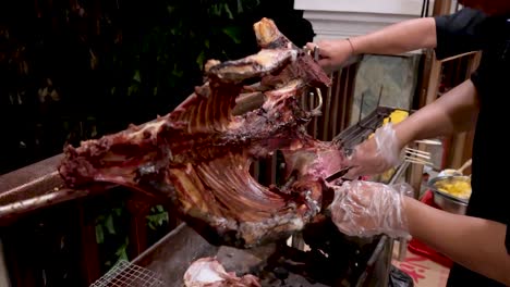Chef's-is-cutting-goat-meat-using-knife-from-grilled-roasted-goat-