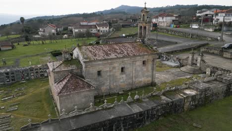 Aerial-orbt-around-backside-of-mossy-old-weathered-church-building-of-Santa-Maria-de-Freas-in-Punxin-Ourense-Galicia-Spain