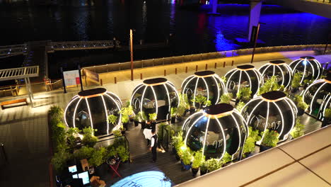 Dubai-UAE,-Cafe-Restaurant-With-Tables-Under-Capsules-at-Night,-Waiters-and-Illumination