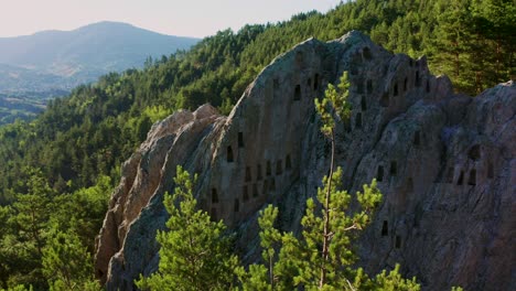 Toma-De-Drones-En-Retirada-De-Las-Cámaras-Funerarias-De-Roca-Prehistóricas-Con-Forma-De-Colmena-Llamadas-La-Roca-De-Las-águilas,-También-Conocida-Como-Orlovi-Skali,-Situada-En-La-Montaña-Ródope-En-Bulgaria