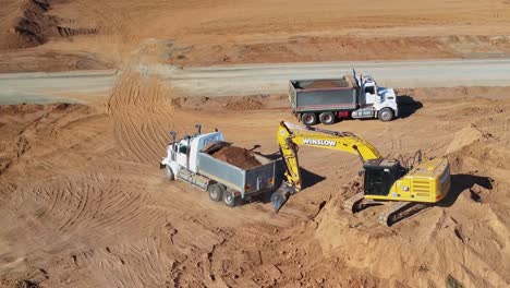 Yarrawonga,-Victoria,-Australien-–-8.-März-2024:-Kipplaster-Fährt-Von-Erdhaufen-Weg,-Nachdem-Bagger-Erde-Auf-Dem-Silverwoods-Anwesen-In-Yarrawonga-Geladen-Haben