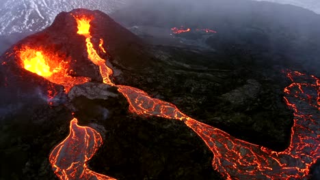 Aerial-cinematic-footage-captured-by-a-4K-drone-showcases-the-unique-sight-of-two-volcanoes-positioned-side-by-side,-both-expelling-lava-rapidly-as-molten-streams-cascade-downwards