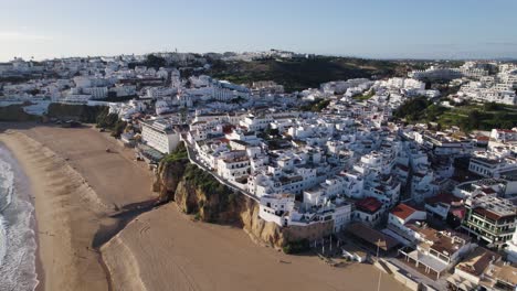 Sunrise-in-coast-city-Albufeira,-Portugal,-beautiful-drone-orbit-white-houses