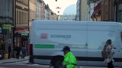 People-and-cars-cross-busy-street-in-autumn-in-Stockholm,-Sweden