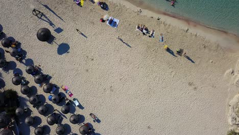 Toma-Aérea-De-Un-Dron-Del-Complejo-Playero-De-Calla-Mondrago,-Que-Muestra-A-Varios-Bañistas-Tomando-El-Sol-Y-Nadando-En-Las-Idílicas-Aguas-Del-Mar-Mediterráneo.