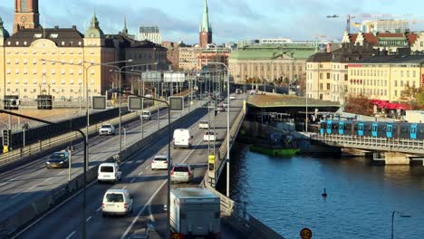 Car-traffic-on-bridge-in-Stockholm,-subway-train-arrives-at-station
