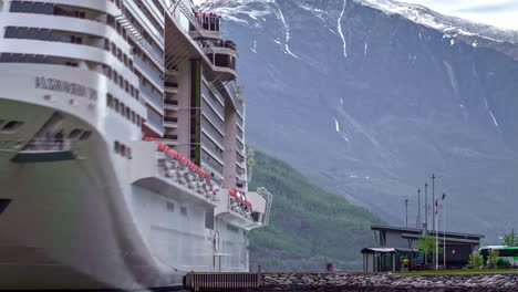 A-cruise-ship-bobbing-on-the-quay-in-a-port-in-Norway,-the-fjord-in-the-background