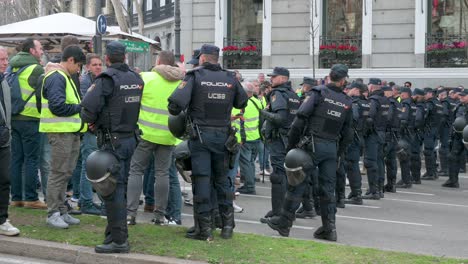 Polizisten-Stehen-Wache,-Als-Sich-Spanische-Landwirte-Und-Agrargewerkschaften-Auf-Der-Plaza-De-La-Independencia-Versammeln,-Um-Gegen-Unlauteren-Wettbewerb,-Agrar--Und-Regierungspolitik-Zu-Protestieren