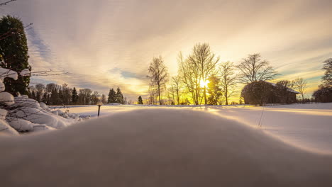 Snowy-rural-scene-with-home-during-sunrise,-time-lapse-view