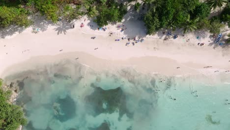 People-relaxing-at-Playa-La-Playita-beach-at-Las-Galeras-in-Samana-peninsula,-Dominican-Republic