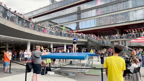 Girl-makes-somersaults-on-trampoline-at-show-with-audience,-Stockholm