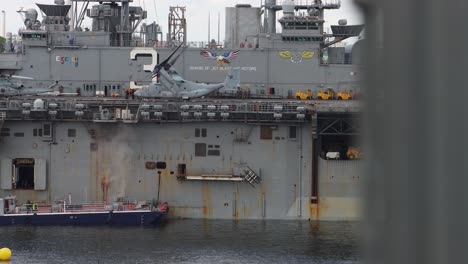 Military-equipment-on-US-battleship-seen-from-behind-wall,-shallow-DOF