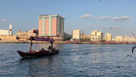 Dreitägige-Bootsfahrt-Auf-Dem-Creek-Canal-Im-Alten-Dubai-Mit-Blick-Auf-Die-Alten-Gebäude-Und-Fliegenden-Möwen