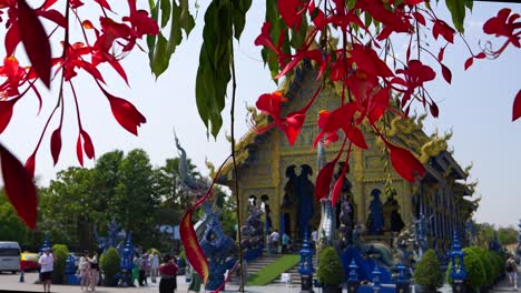 Famous-blue-temple-Rong-Sue-Ten-in-Chiang-Rai-behind-flowers