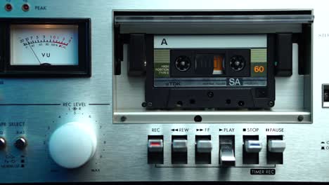 Listening-Audio-Cassette-Tape-in-Vintage-Deck-Player-With-VU-Meter-Level-Scale,-Close-Up