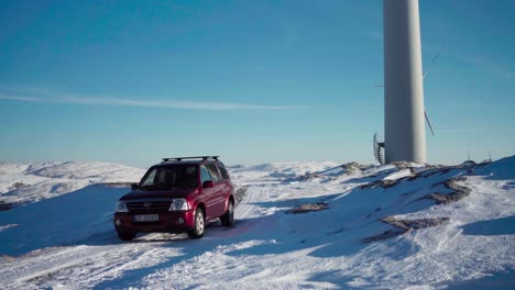 Un-Automóvil-Estacionado-Cerca-Del-Molino-De-Viento-Durante-El-Invierno-En-Bessaker,-Condado-De-Trondelag,-Noruega---Toma-Manual