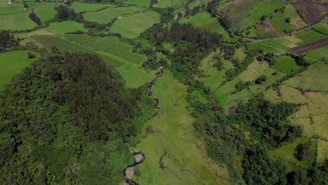 Eagle-eye-view-of-a-drone-clip-over-a-green-field-and-canyon-in-Puichig,-Equador