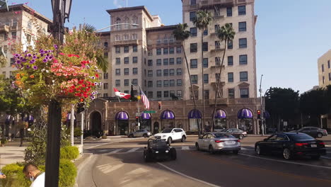 Golden-Triangle,-Beverly-Hills-Downtown,-Traffic-on-Rodeo-Drive,-Wilshire-Hotel-Four-Seasons-Hotel-on-Sunny-Day