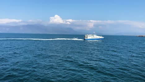 Blaue-Fähre-überquert-Die-Isländischen-Gewässer-Mit-Bergen-Unter-Einem-Klaren-Himmel,-Tagsüber,-Mittlere-Aufnahme