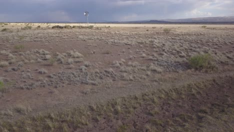 Drone-—-slowly-moving-across-the-landscape-with-windmill-and-skies-in-background,-Texas